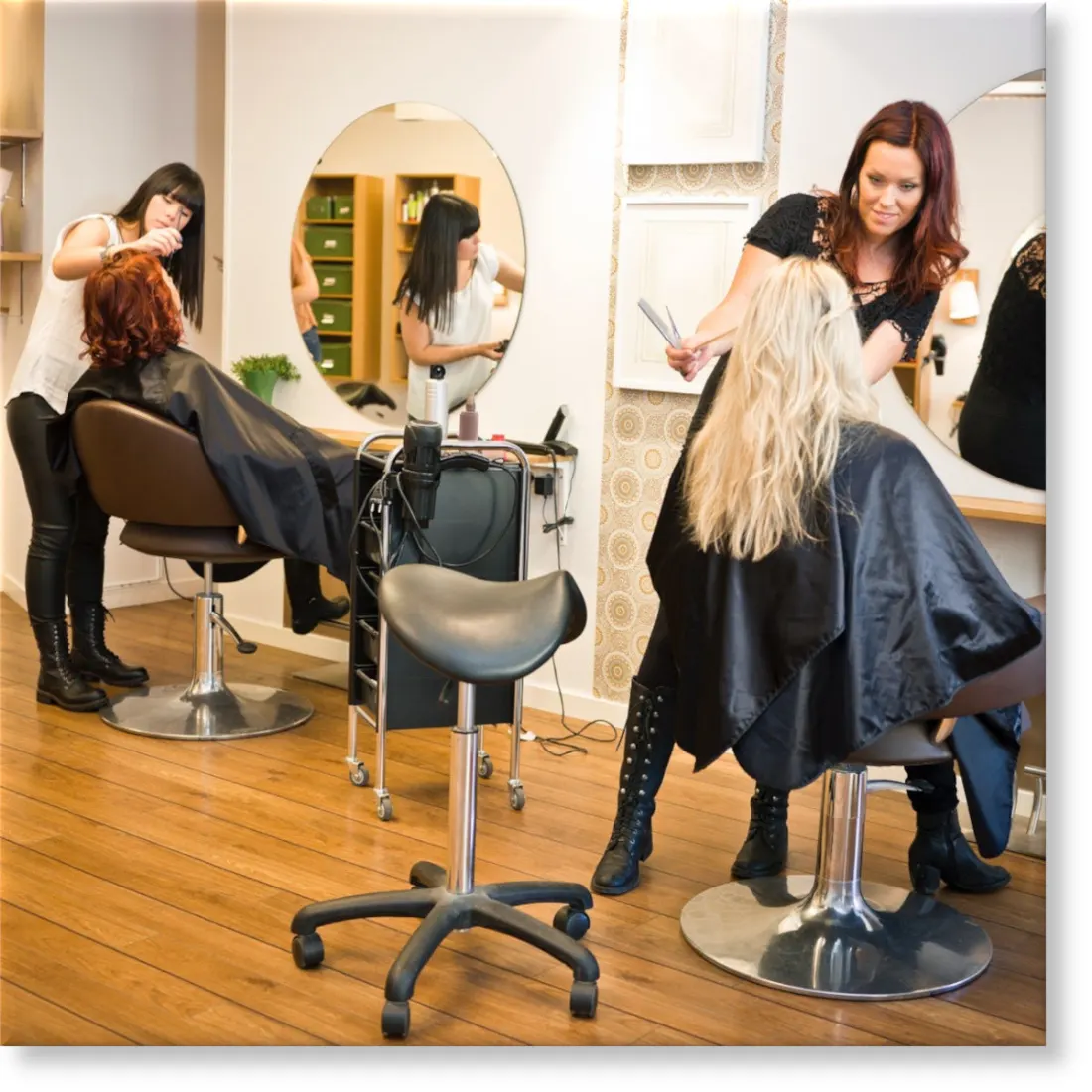 Two hairstylists working in a busy salon